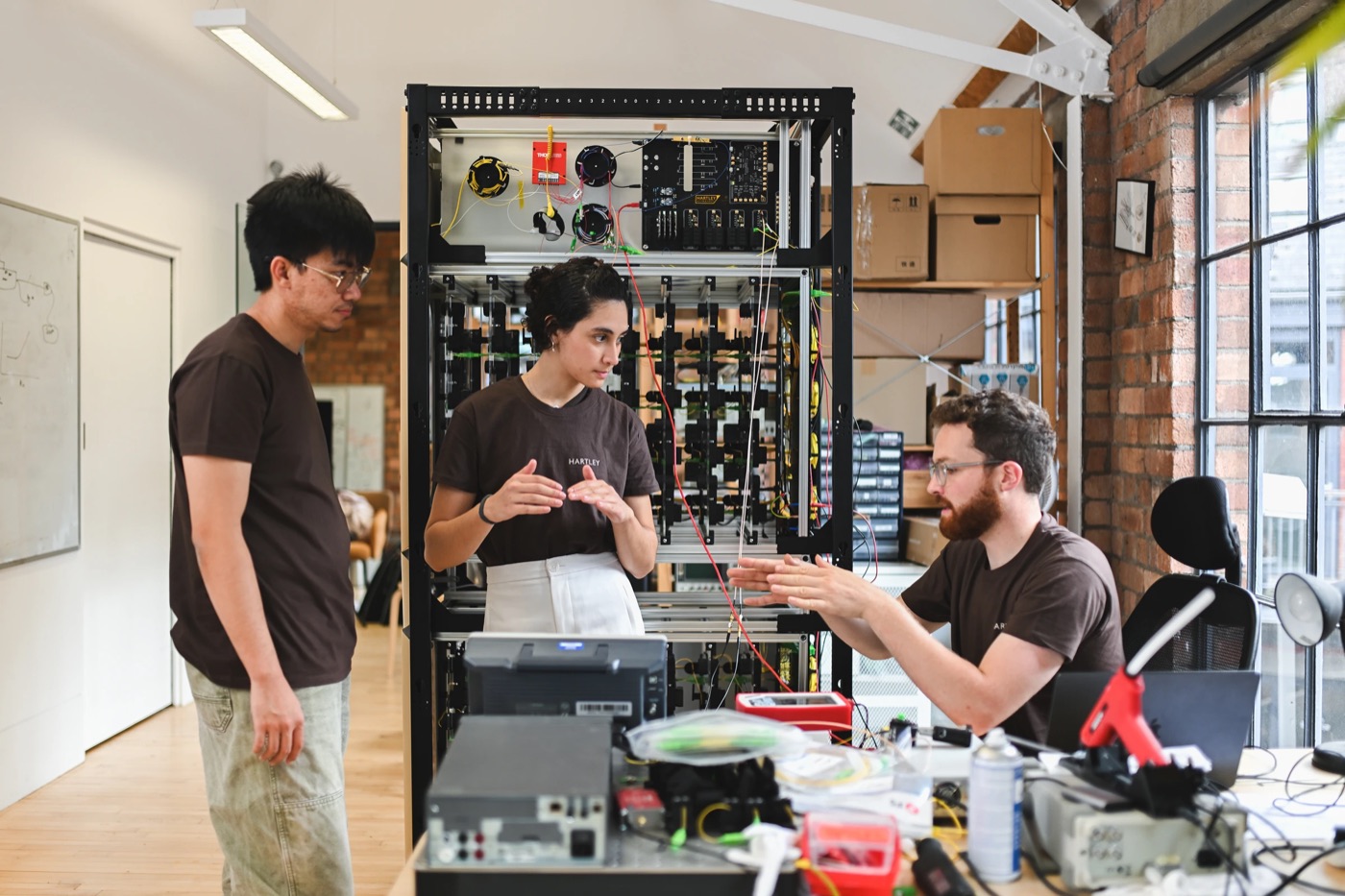 The Hartley Ultrafast team discussing their work beside laboratory equipment